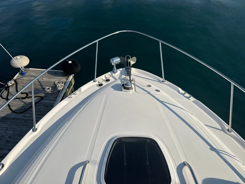Slide: The Image of The 2003 Sea Ray 340 Sundancer is docked. View of the bow deck and surrounding water. - 16
