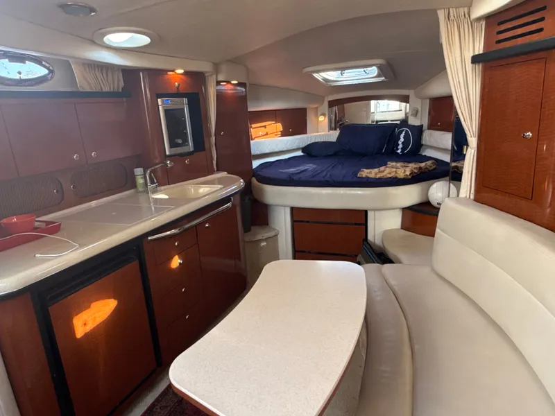 Slide: The Image of The interior cabin of a 2003 Sea Ray 340 Sundancer features a cozy seating area and a bed. - 18