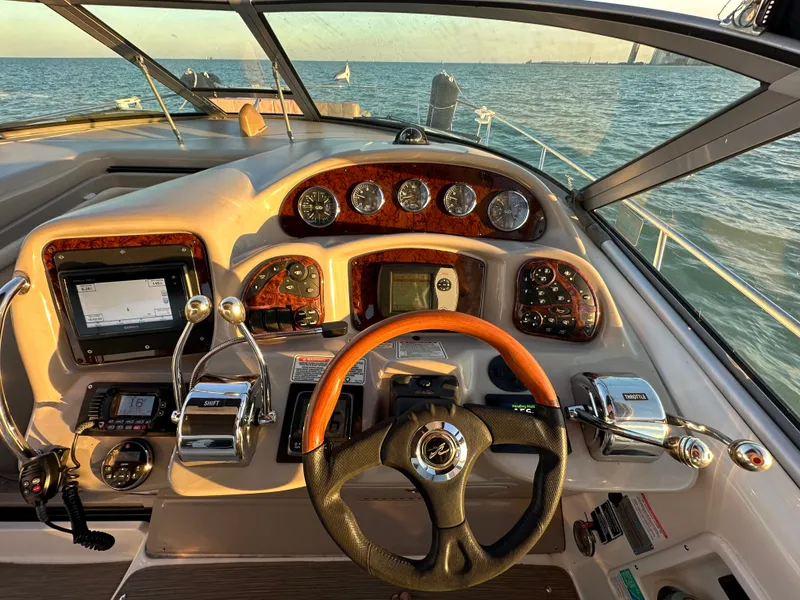 Slide: The Image of The cockpit of a 2003 Sea Ray 340 Sundancer with wood trim and modern instruments. - 13