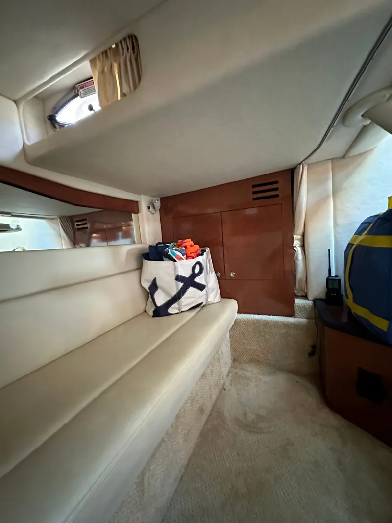 Slide: The Image of Interior of a 2003 Sea Ray 340 Sundancer with cream upholstery and wooden cabinetry. - 19