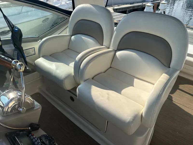 Slide: The Image of Two cushioned captain's chairs in a 2003 Sea Ray 340 Sundancer, featuring armrests and a helm console. - 11