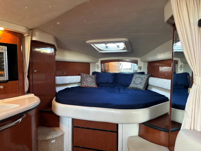 Slide: The Image of The cabin of a 2003 Sea Ray 340 Sundancer with a large bed and wooden cabinetry. - 20