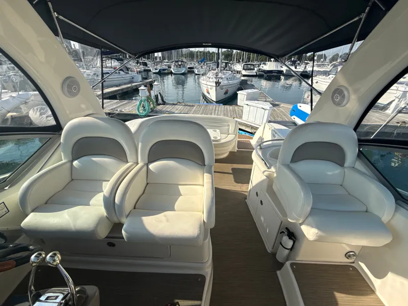 Slide: The Image of The image shows the cockpit of a 2003 Sea Ray 340 Sundancer with white leather seats and a marina view. - 9