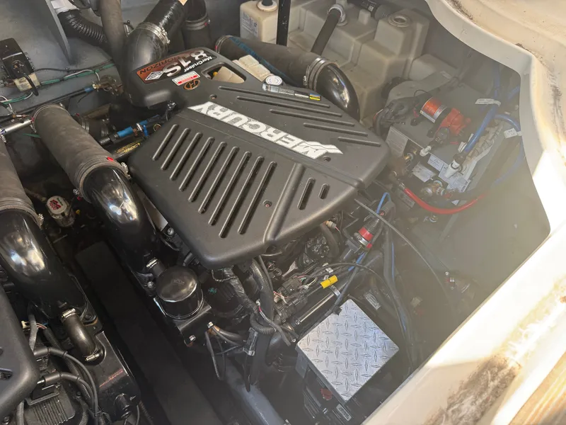 Slide: The Image of The engine compartment of a 2003 Sea Ray 340 Sundancer shows a neatly installed engine with various components. - 27