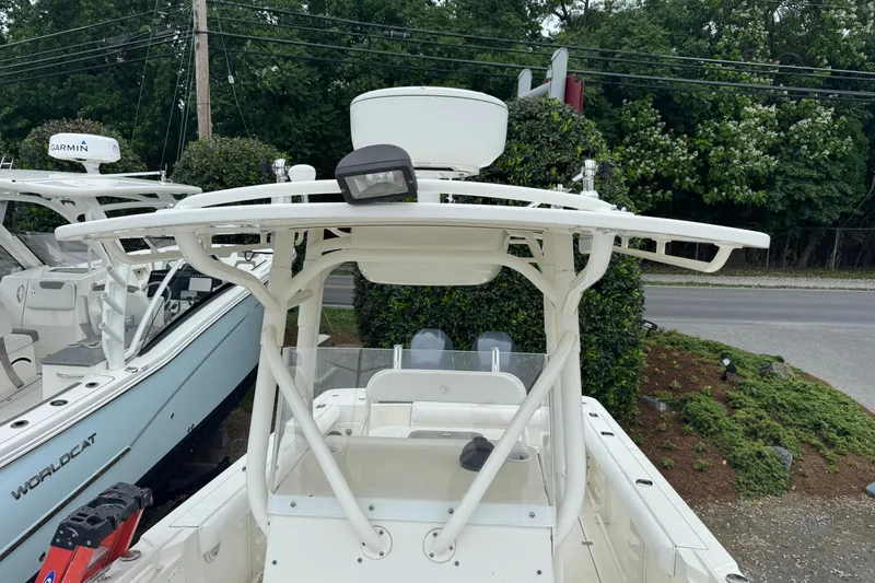 Slide: The Image of 2007 Edgewater 245CC boat with T-top and Garmin radar, parked outdoors. - 9