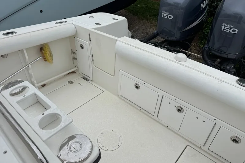 Slide: The Image of 2007 Edgewater 245CC boat interior with Yamaha 150 engines, storage compartments, and rod holders. - 8