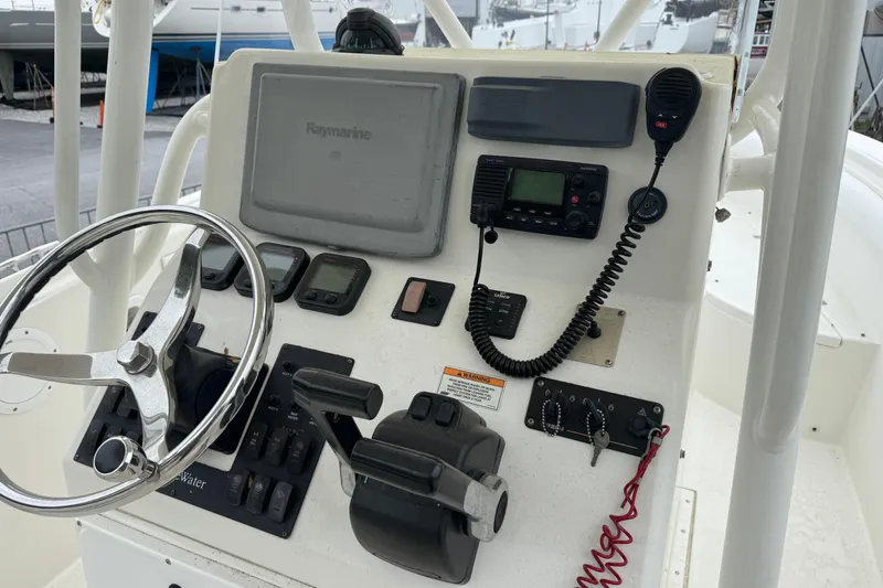 Slide: The Image of Control panel of a 2007 Edgewater 245CC boat with steering wheel and navigation equipment. - 5