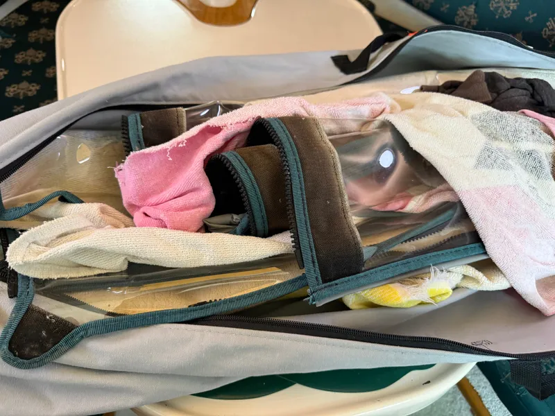 Slide: The Image of A pile of fabrics and plastic windows on a boat seat. - 14