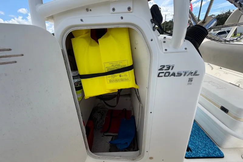 Slide: The Image of Open storage compartment on 2015 NauticStar 231 Coastal boat with life jackets inside. - 36