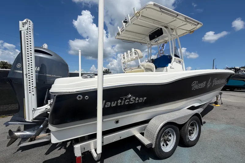 Slide: The Image of 2015 NauticStar 231 Coastal boat on trailer under blue sky. - 2