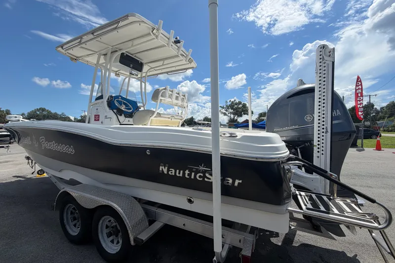 Slide: The Image of 2015 NauticStar 231 Coastal boat on trailer under clear blue sky. - 7