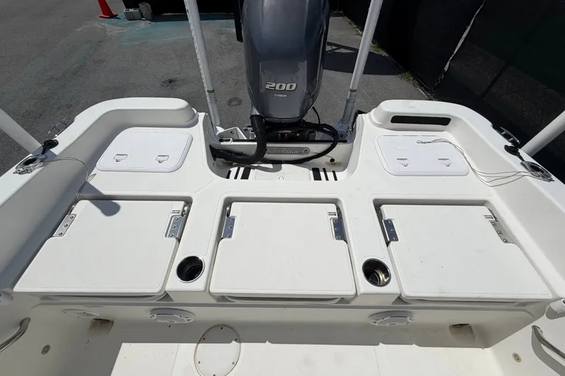 Slide: The Image of 2015 NauticStar 231 Coastal boat deck with Yamaha 200 engine, storage compartments visible. - 59