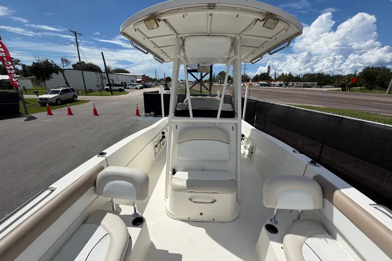 Slide: The Image of 2015 NauticStar 231 Coastal boat interior with seating and console, parked outdoors. - 53
