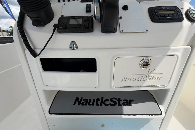 Slide: The Image of 2015 NauticStar 231 Coastal boat dashboard with controls and branding. - 19