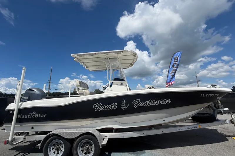 Slide: The Image of 2015 NauticStar 231 Coastal boat on trailer under blue sky with clouds. - 1