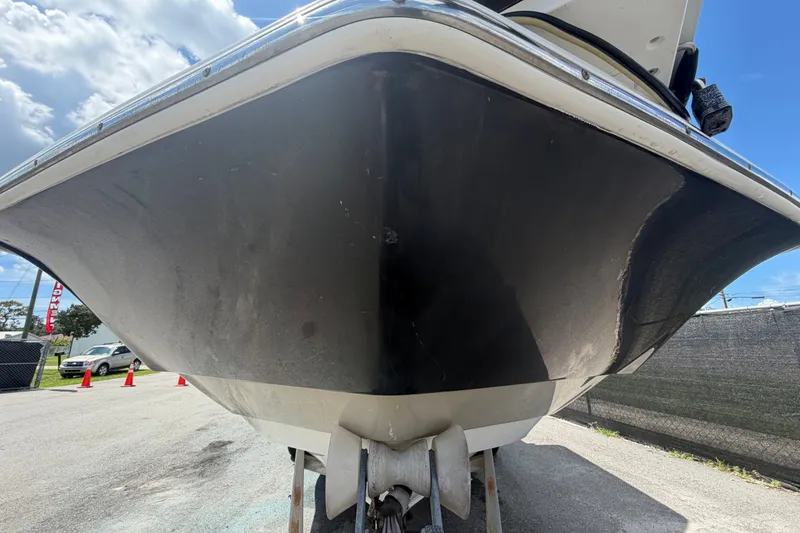 Slide: The Image of 2015 NauticStar 231 Coastal boat hull, viewed from below, parked outdoors. - 10