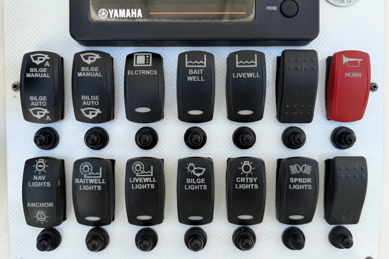 Slide: The Image of Control panel of a 2015 NauticStar 231 Coastal boat with various switches and Yamaha display. - 25