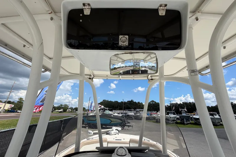 Slide: The Image of 2015 NauticStar 231 Coastal boat interior view with clear skies and marina background. - 31