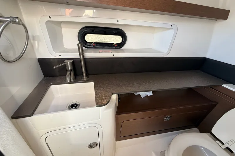 Slide: The Image of 2019 Sea Ray SDX 290 Outboard interior with sink, countertop, and porthole window. - 31