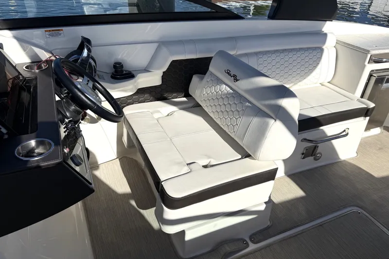 Slide: The Image of 2019 Sea Ray SDX 290 Outboard interior with white seating and steering wheel. - 25