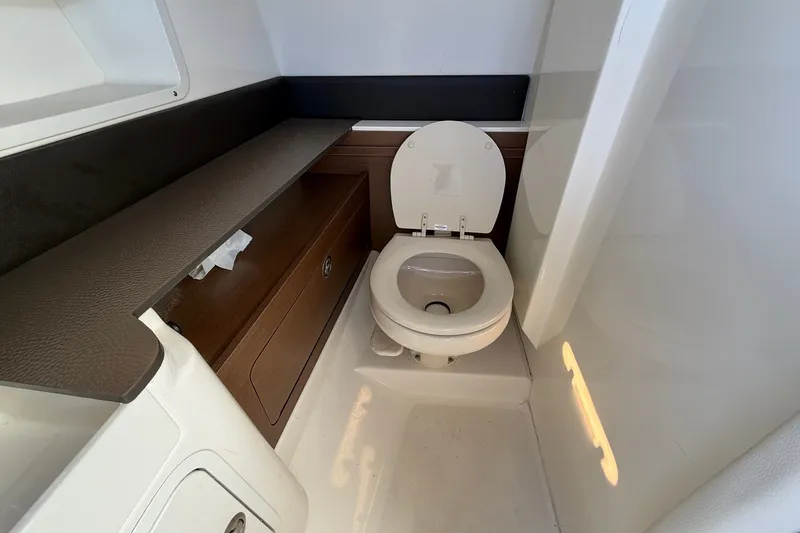 Slide: The Image of 2019 Sea Ray SDX 290 Outboard boat bathroom with toilet and storage cabinet. - 30