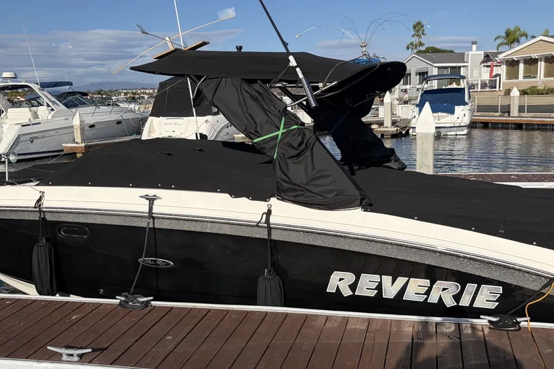 Slide: The Image of 2019 Sea Ray SDX 290 Outboard boat docked, covered, with "Reverie" name visible. - 7