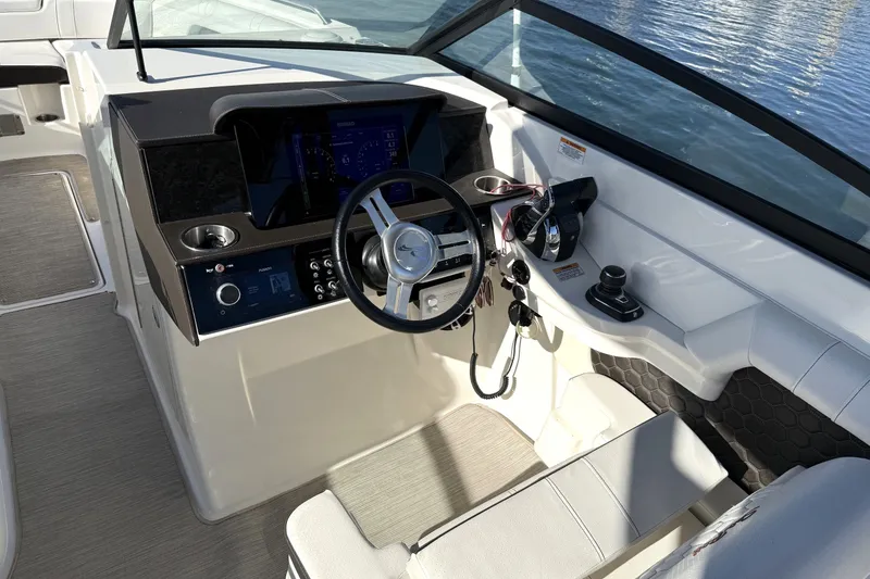 Slide: The Image of 2019 Sea Ray SDX 290 Outboard helm with steering wheel and control panel. - 26