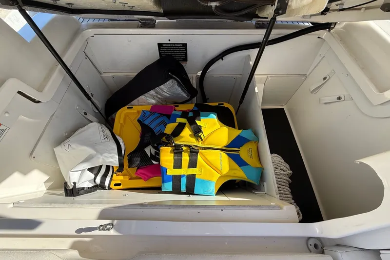 Slide: The Image of Storage compartment of 2019 Sea Ray SDX 290 Outboard with life jackets and gear. - 14