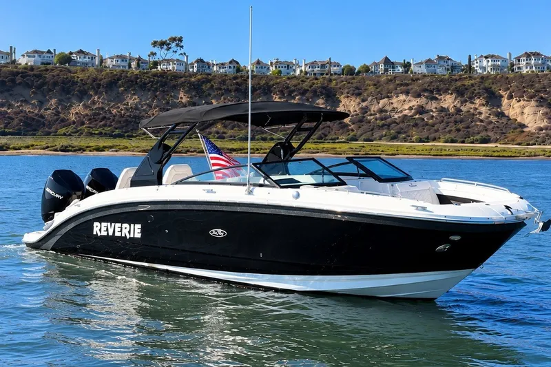 The Image of 2019 Sea Ray SDX 290 Outboard boat on water, with scenic coastal background. - 0
