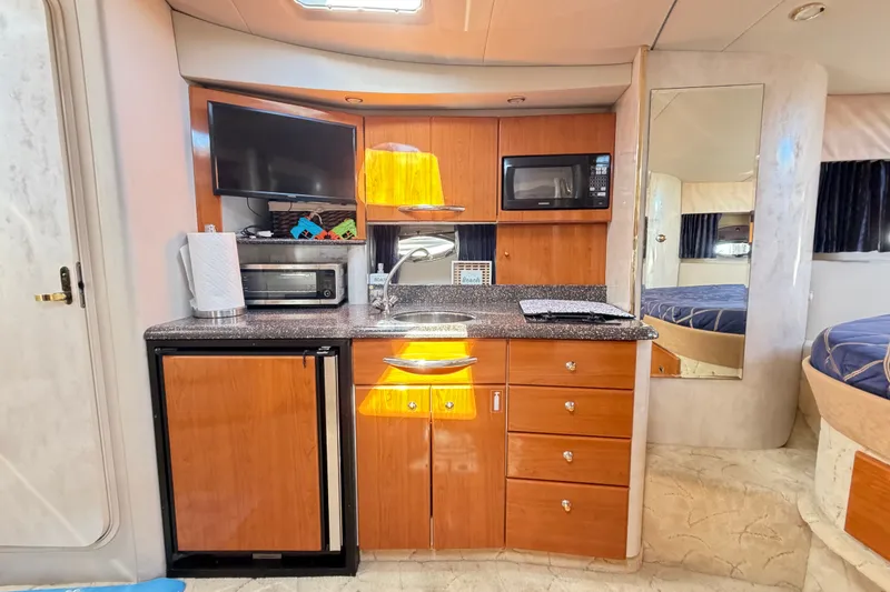Slide: The Image of 2003 Formula 37 Performance Cruiser interior with kitchenette, featuring wood cabinets, sink, and appliances. - 30