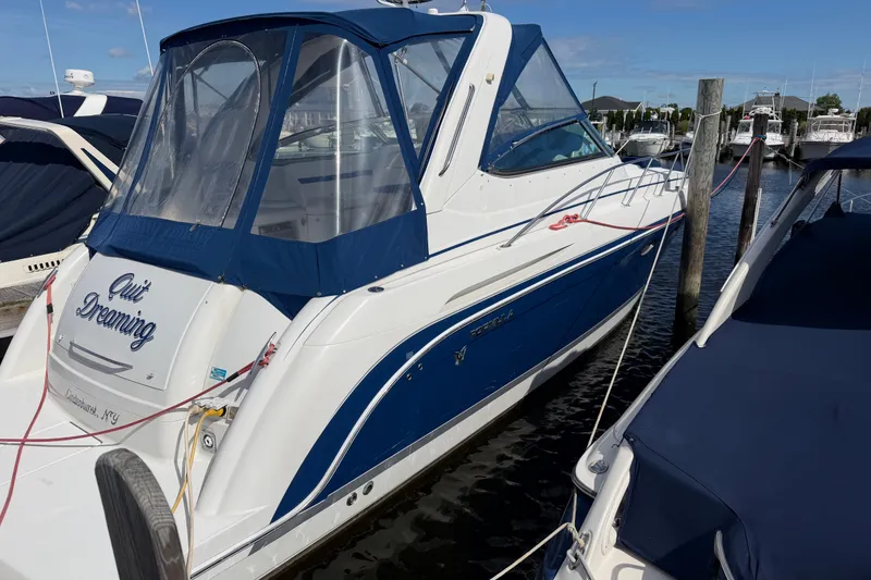 Slide: The Image of 2003 Formula 37 Performance Cruiser docked at marina, featuring blue and white design. - 4