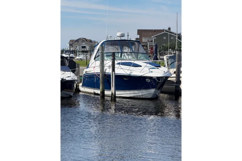 Slide: The Image of 2003 Formula 37 Performance Cruiser docked at marina, blue and white exterior. - 5