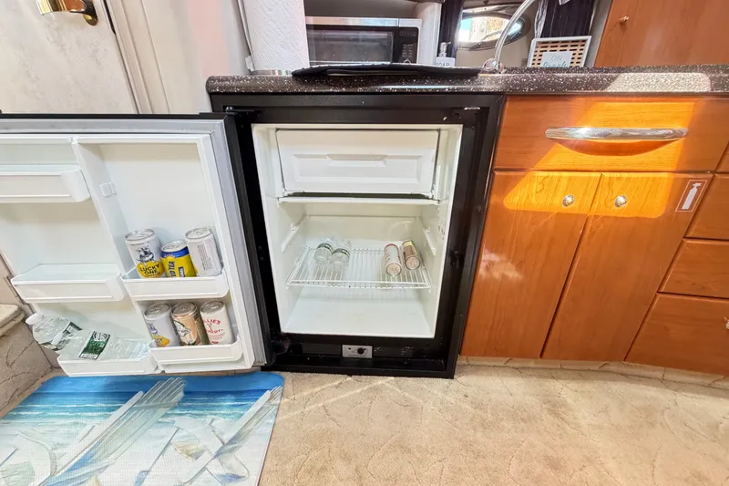 Slide: The Image of Mini fridge in 2003 Formula 37 Performance Cruiser, stocked with beverages, in wooden cabinet setting. - 33