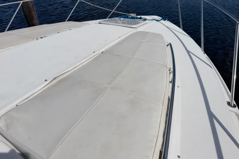 Slide: The Image of 2003 Formula 37 Performance Cruiser deck with cushioned seating, docked by the water. - 10
