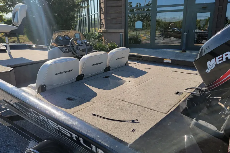 Slide: The Image of 2008 Crestliner CX 17 Bass boat interior with seating and controls, parked outdoors. - 5