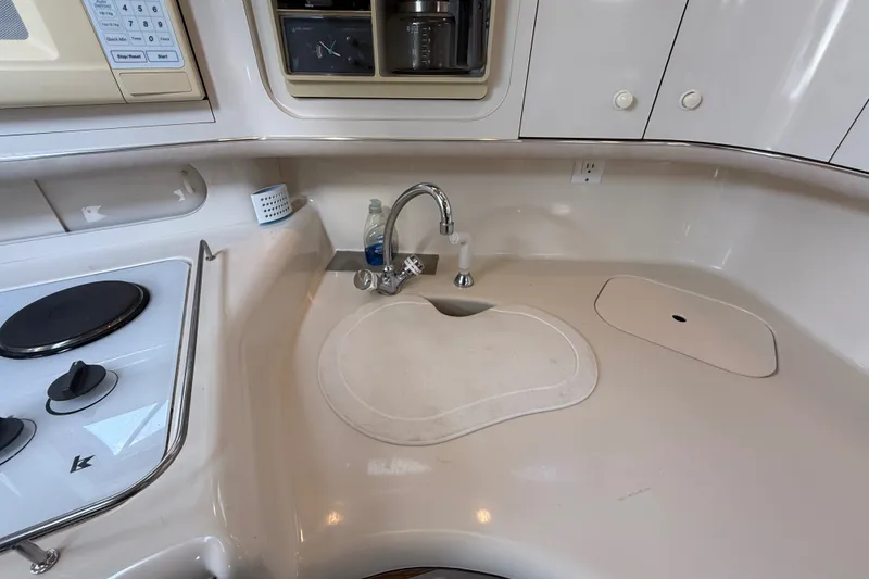 Slide: The Image of 1996 Sea Ray Sundancer 370 kitchen area with sink, stove, and storage cabinets. - 38