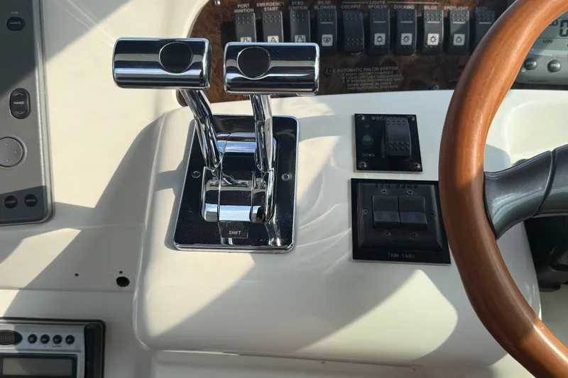 Slide: The Image of 1996 Sea Ray Sundancer 370 helm controls with dual throttle levers and wooden steering wheel. - 25