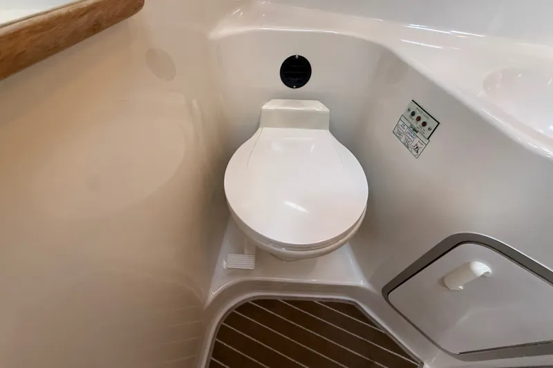 Slide: The Image of 1996 Sea Ray Sundancer 370 boat bathroom with compact toilet and wooden flooring. - 48