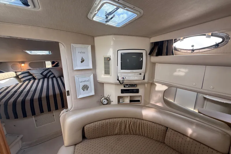 Slide: The Image of Interior of a 1996 Sea Ray Sundancer 370 yacht with cozy seating and a small TV. - 44