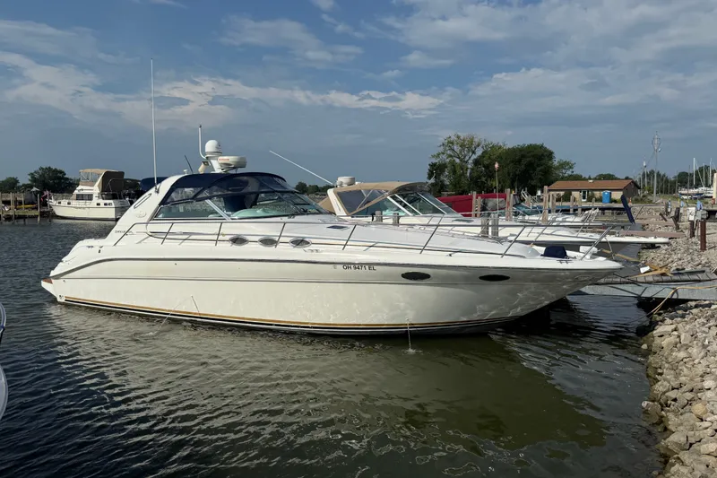 The Image of 1996 Sea Ray Sundancer 370 yacht docked at a marina under a clear sky. - 0