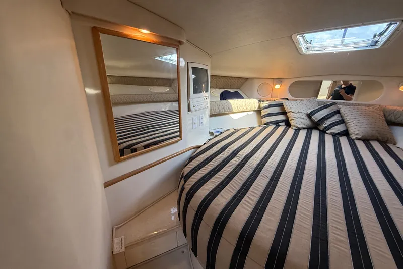 Slide: The Image of Interior cabin of 1996 Sea Ray Sundancer 370 with striped bedding and mirror. - 54