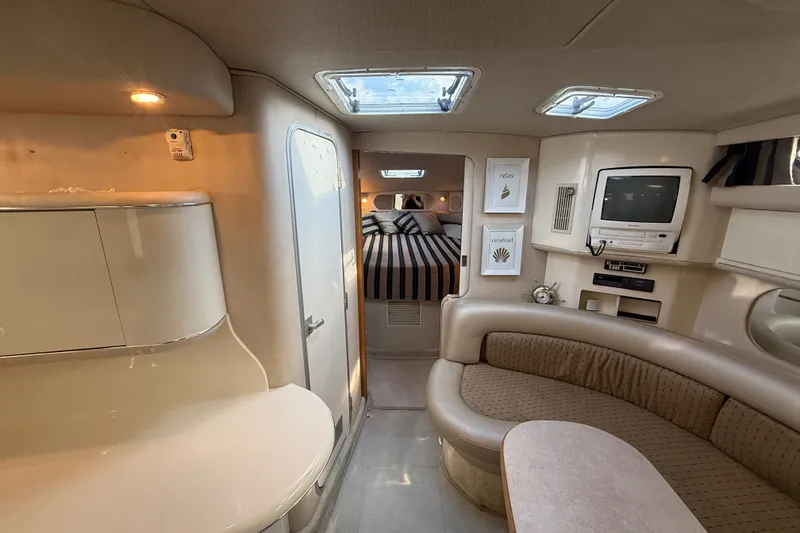 Slide: The Image of Interior of a 1996 Sea Ray Sundancer 370 yacht, featuring cozy seating and a compact entertainment area. - 46