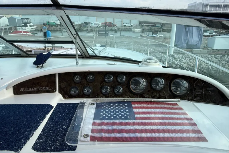 Slide: The Image of 1996 Sea Ray Sundancer 370 dashboard with American flag, marina view in background. - 20