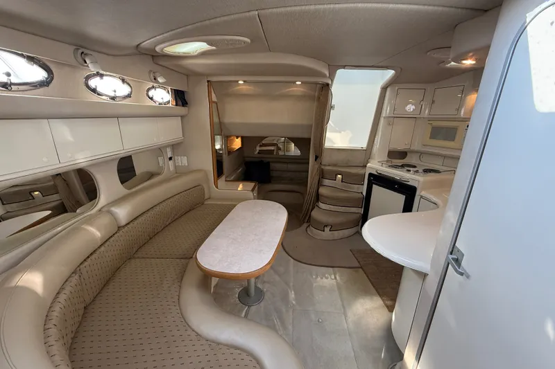Slide: The Image of Interior of a 1996 Sea Ray Sundancer 370 yacht, featuring a cozy seating area and kitchenette. - 57