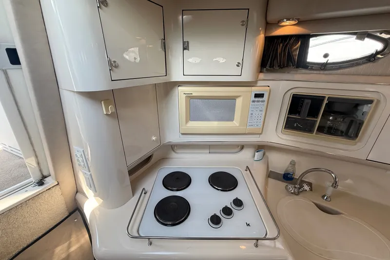 Slide: The Image of Compact kitchen area in a 1996 Sea Ray Sundancer 370 yacht with stove, microwave, and sink. - 37