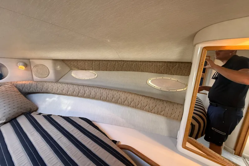 Slide: The Image of Interior cabin of 1996 Sea Ray Sundancer 370 with striped bedding and porthole windows. - 56