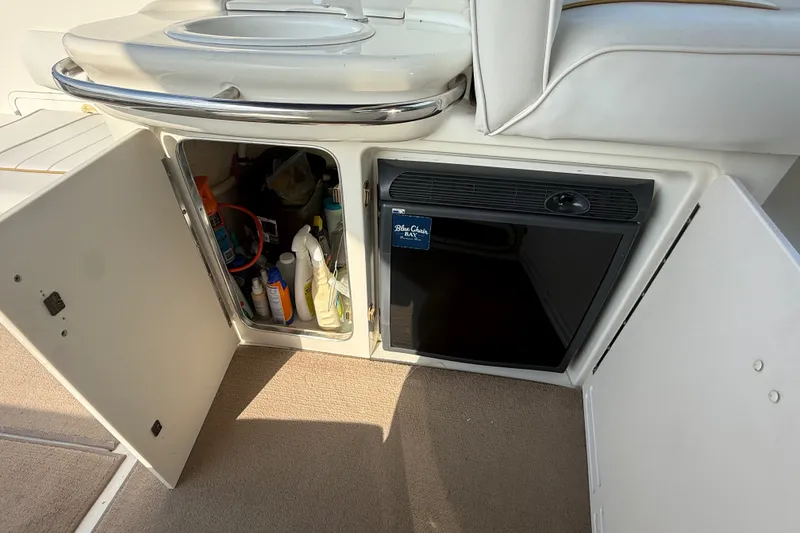 Slide: The Image of 1996 Sea Ray Sundancer 370 interior with open storage and mini fridge. - 32