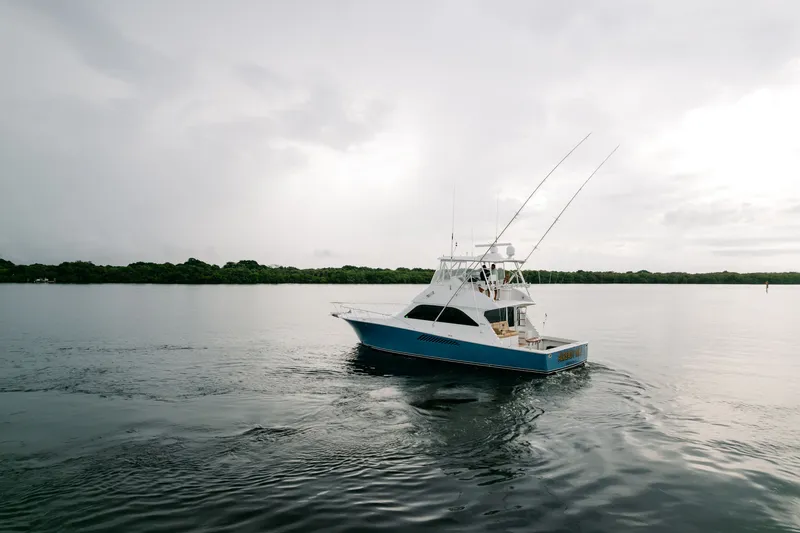 Slide: The Image of 2003 Viking 48 Convertible yacht cruising on calm waters under cloudy skies. - 9