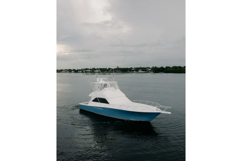 Slide: The Image of 2003 Viking 48 Convertible yacht on calm waters under cloudy skies. - 4
