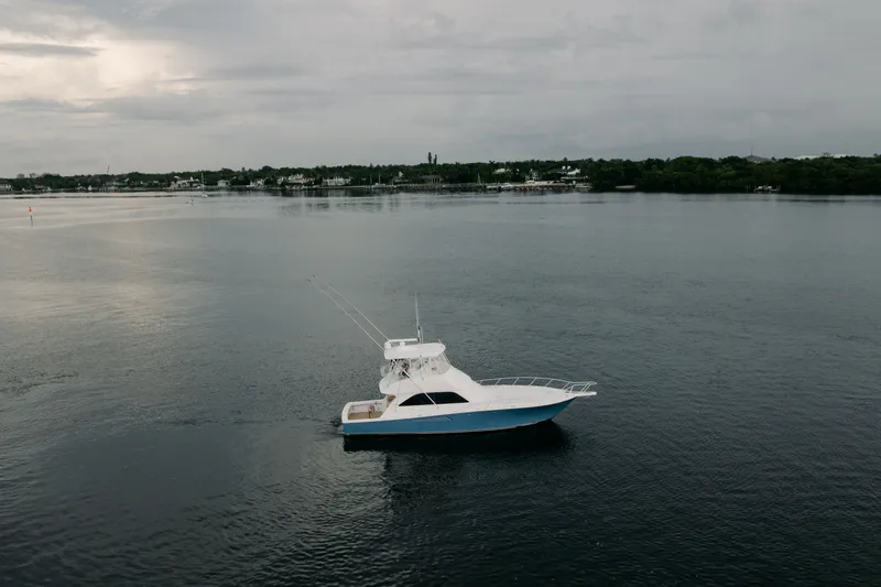 Slide: The Image of 2003 Viking 48 Convertible yacht on calm waters under cloudy skies. - 3